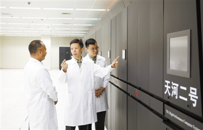 Fig. 4 Xiao Liquan (middle), director of Computer Research Institute, School of Computer Science, National University of Defense Technology, discussed with team members in the high-performance computer room of Tianhe II. Xinhua news agency