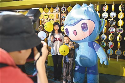 On May 7th, in front of the "3D Smiling Wall" of Hubin Pedestrian Street in Hangzhou, Zhejiang Province, the photographer took a group photo for tourists and Chen Chen, one of the mascots of Hangzhou Asian Games.